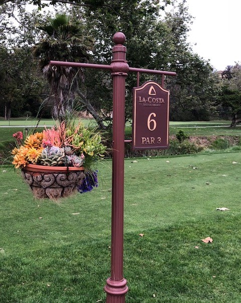 cast bronze tee sign with decorative planter element 
